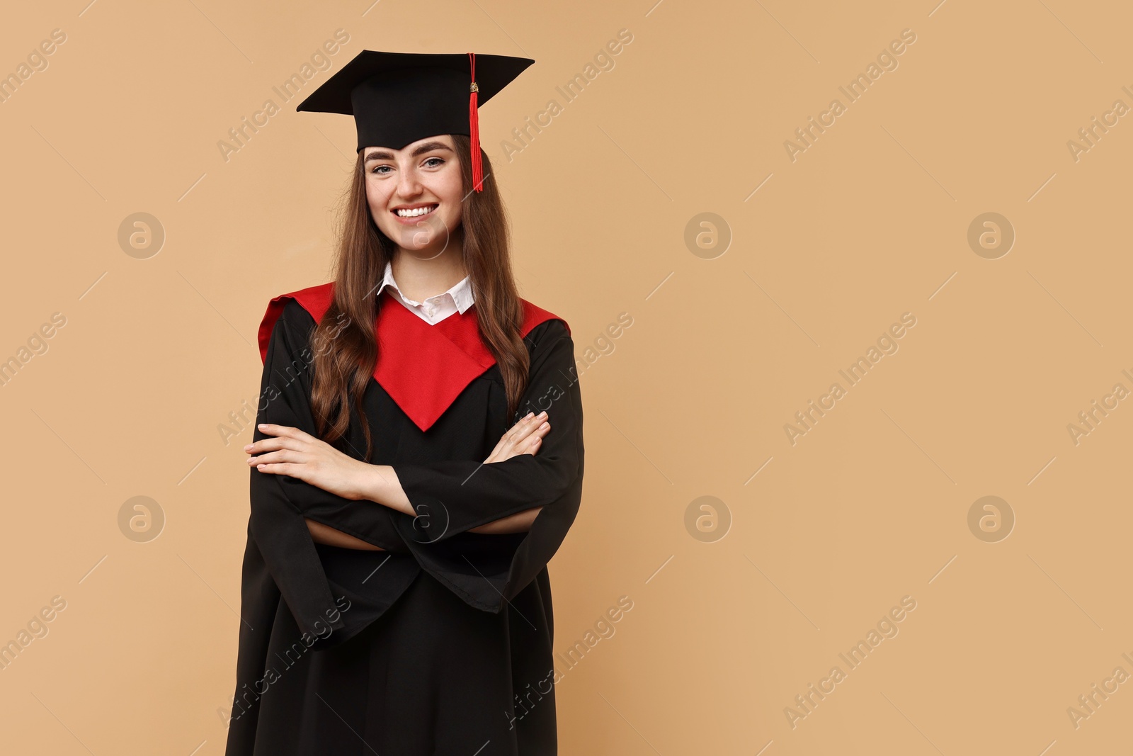 Photo of Happy student with crossed arms after graduation on beige background. Space for text