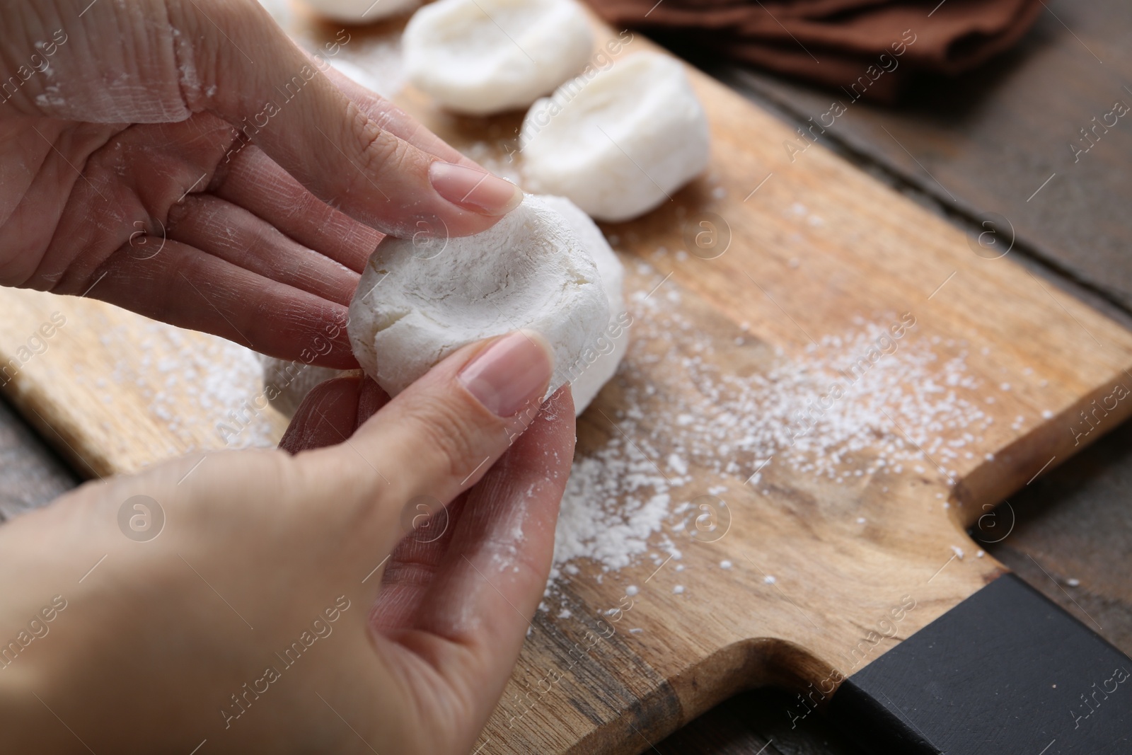 Photo of Woman making tasty mochi at wooden table, closeup