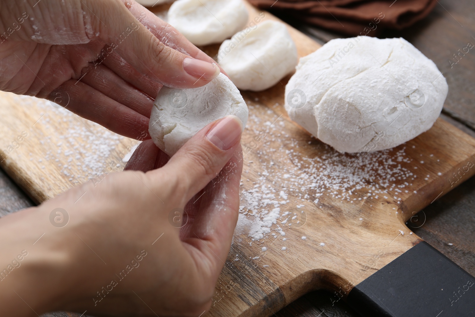 Photo of Woman making tasty mochi at wooden table, closeup