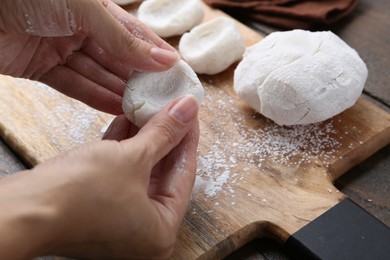 Photo of Woman making tasty mochi at wooden table, closeup