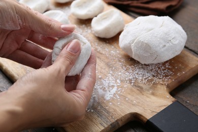 Photo of Woman making tasty mochi at wooden table, closeup