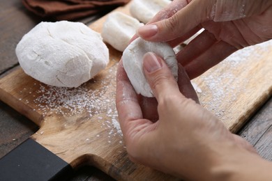 Photo of Woman making tasty mochi at wooden table, closeup