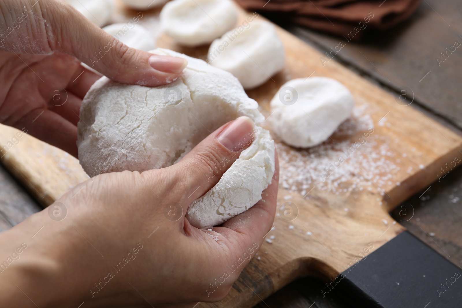 Photo of Woman making tasty mochi at wooden table, closeup