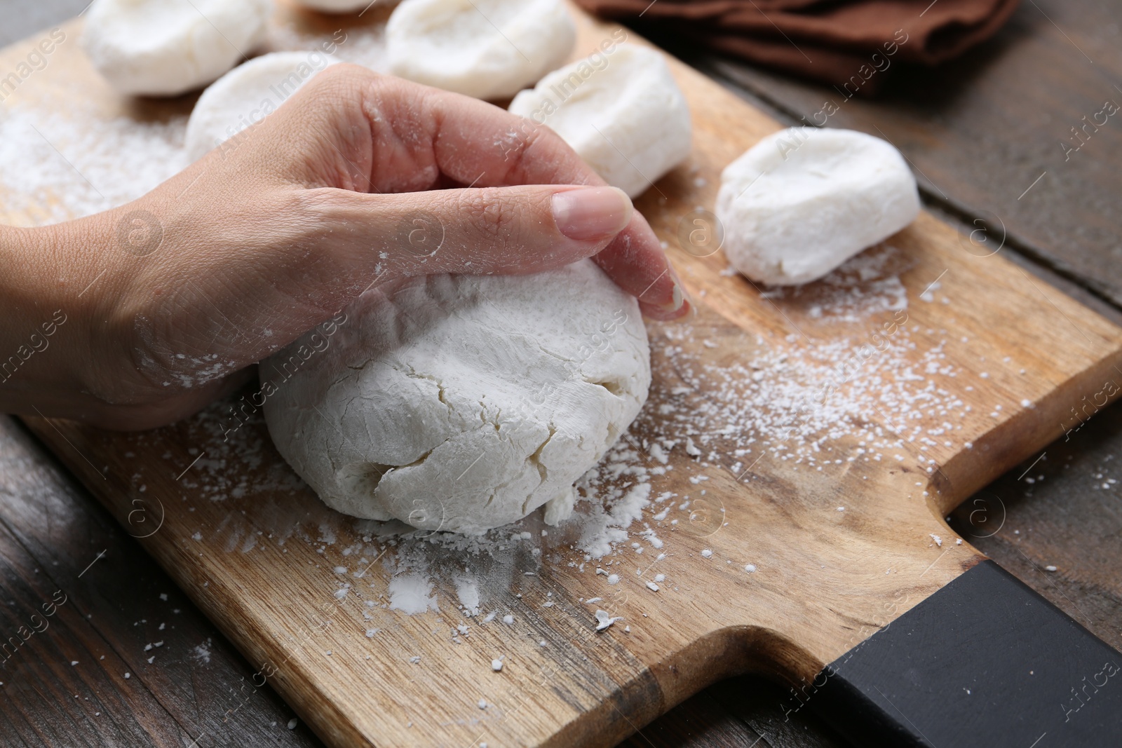 Photo of Woman making tasty mochi at wooden table, closeup