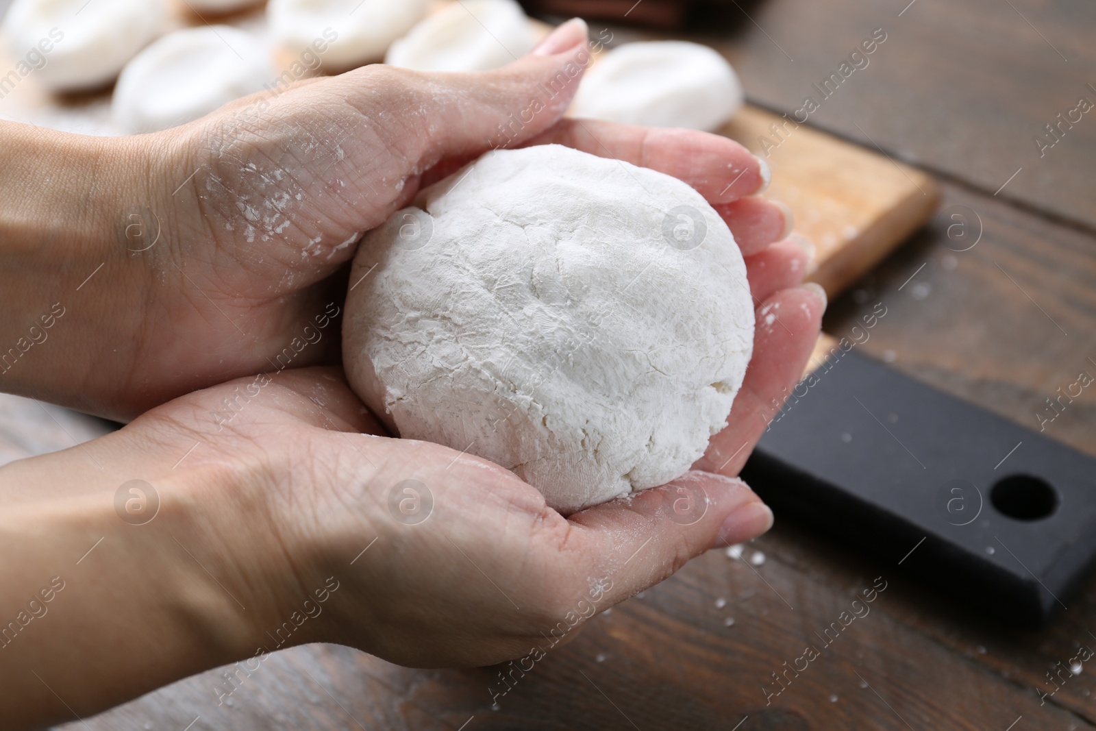 Photo of Woman making tasty mochi at wooden table, closeup