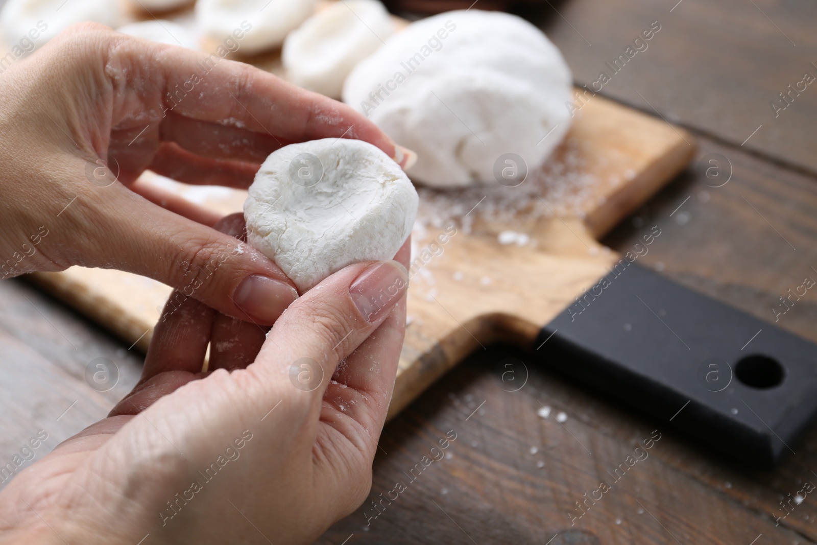 Photo of Woman making tasty mochi at wooden table, closeup