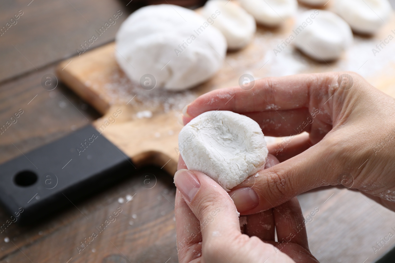 Photo of Woman making tasty mochi at wooden table, closeup