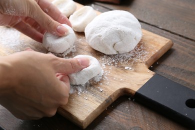 Photo of Woman making tasty mochi at wooden table, closeup