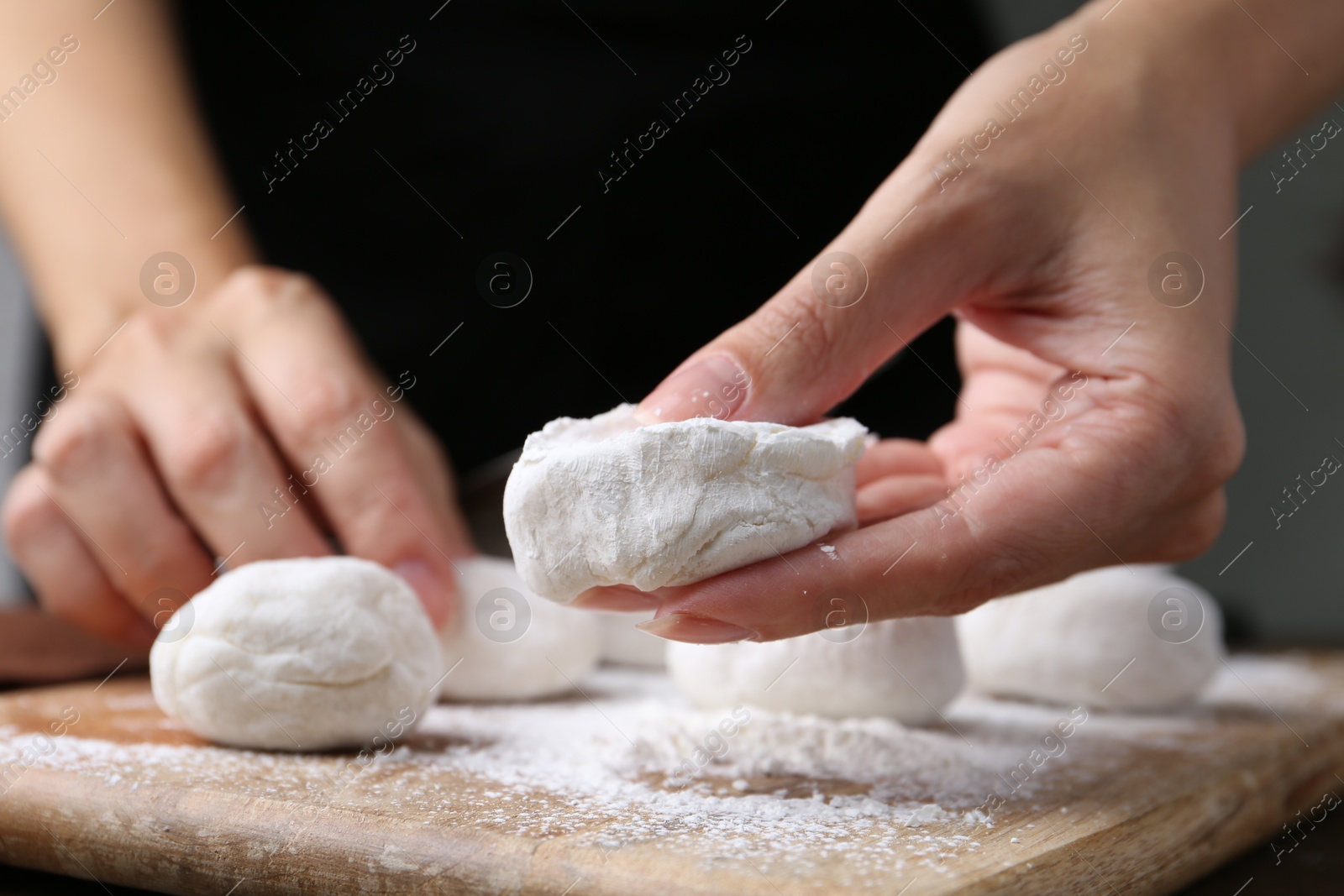 Photo of Woman making tasty mochi at wooden table, closeup