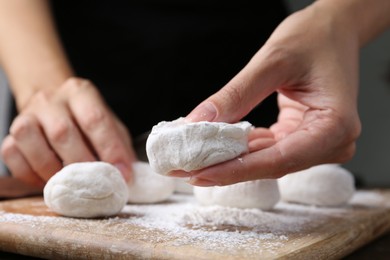 Photo of Woman making tasty mochi at wooden table, closeup