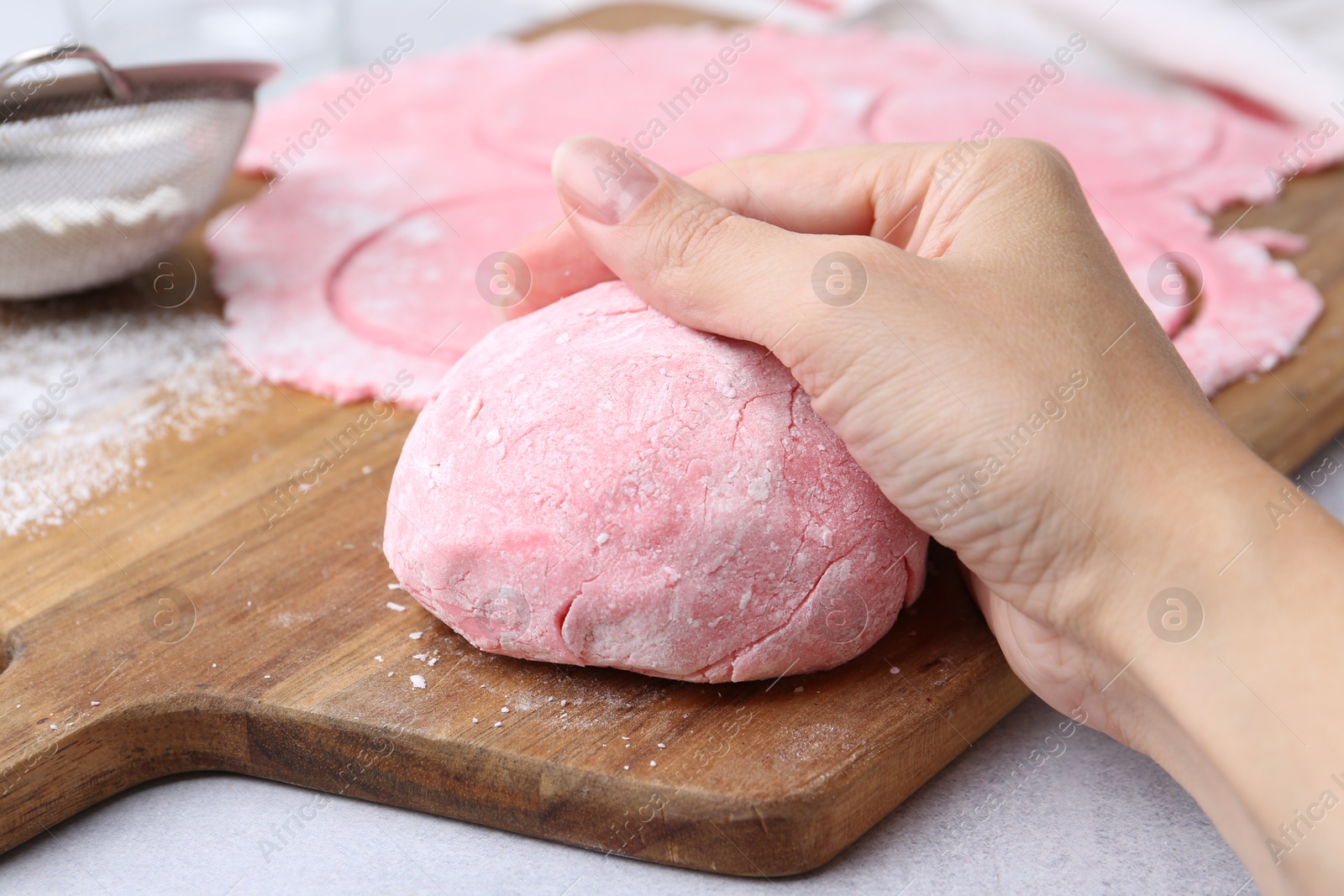 Photo of Woman making tasty mochi at white table, closeup