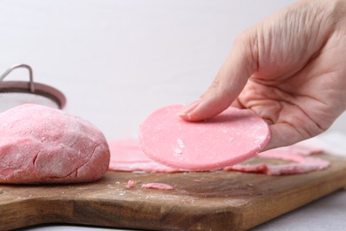 Woman making tasty mochi at white table, closeup