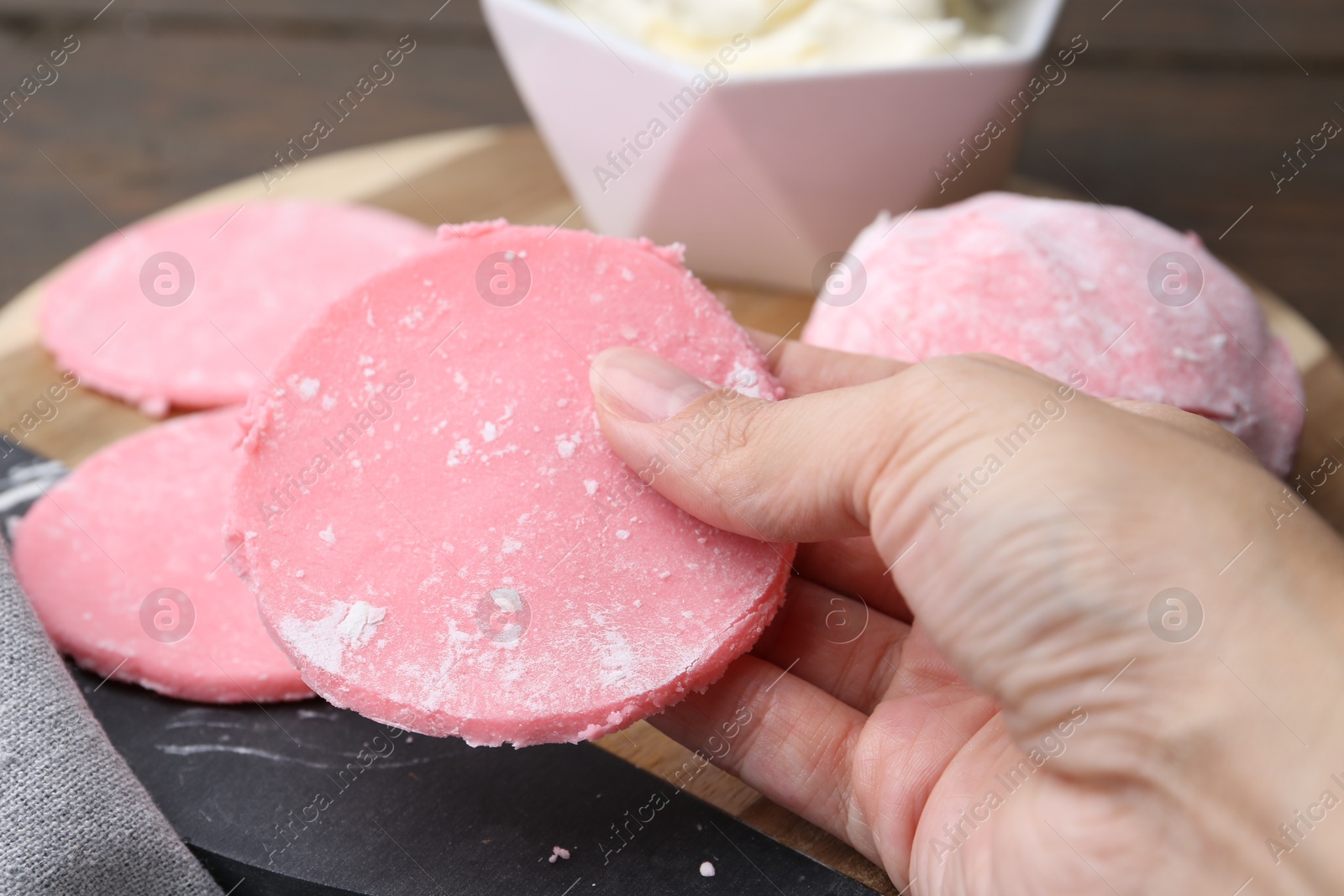 Photo of Woman making tasty mochi at wooden table, closeup