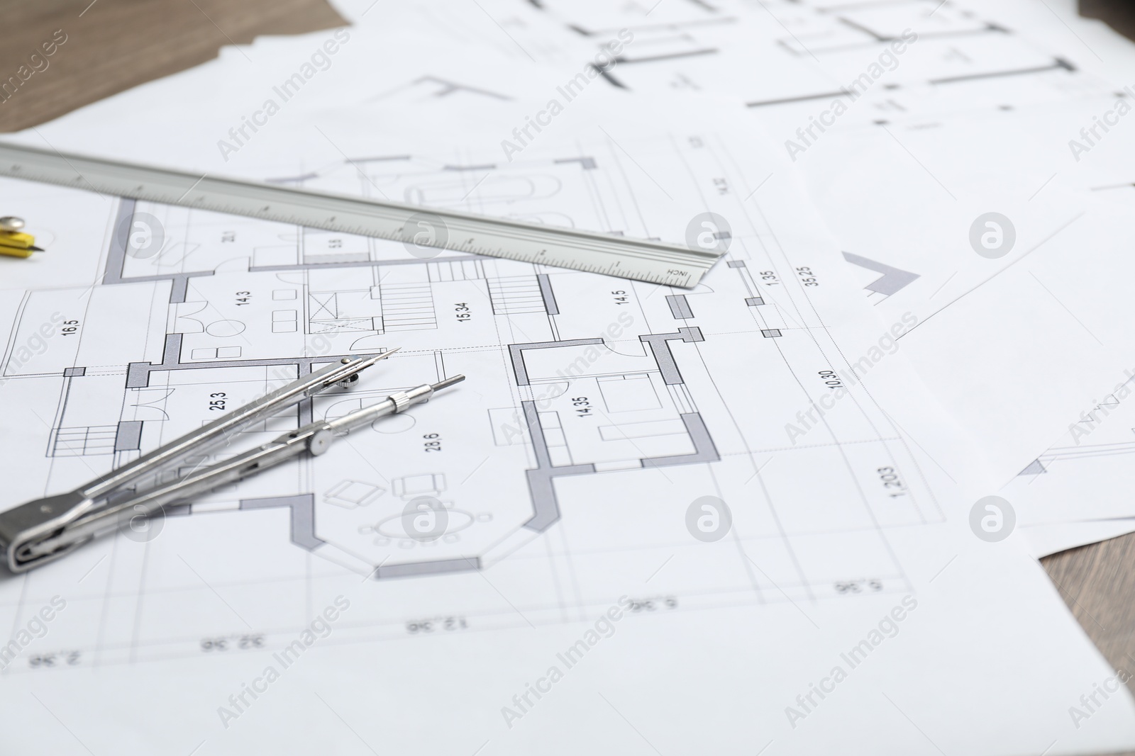 Photo of Different architectural drawings, divider and ruler on table, closeup