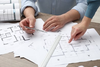 Architects working with project, closeup. Different technical drawings on wooden table