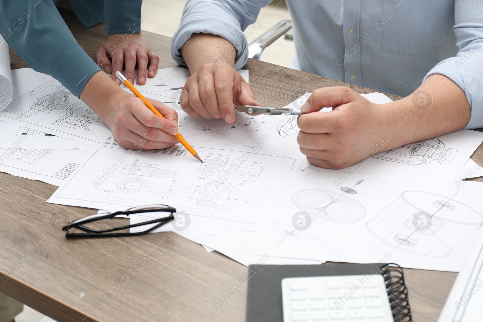 Photo of Engineers working with project, closeup. Different technical drawings on wooden table