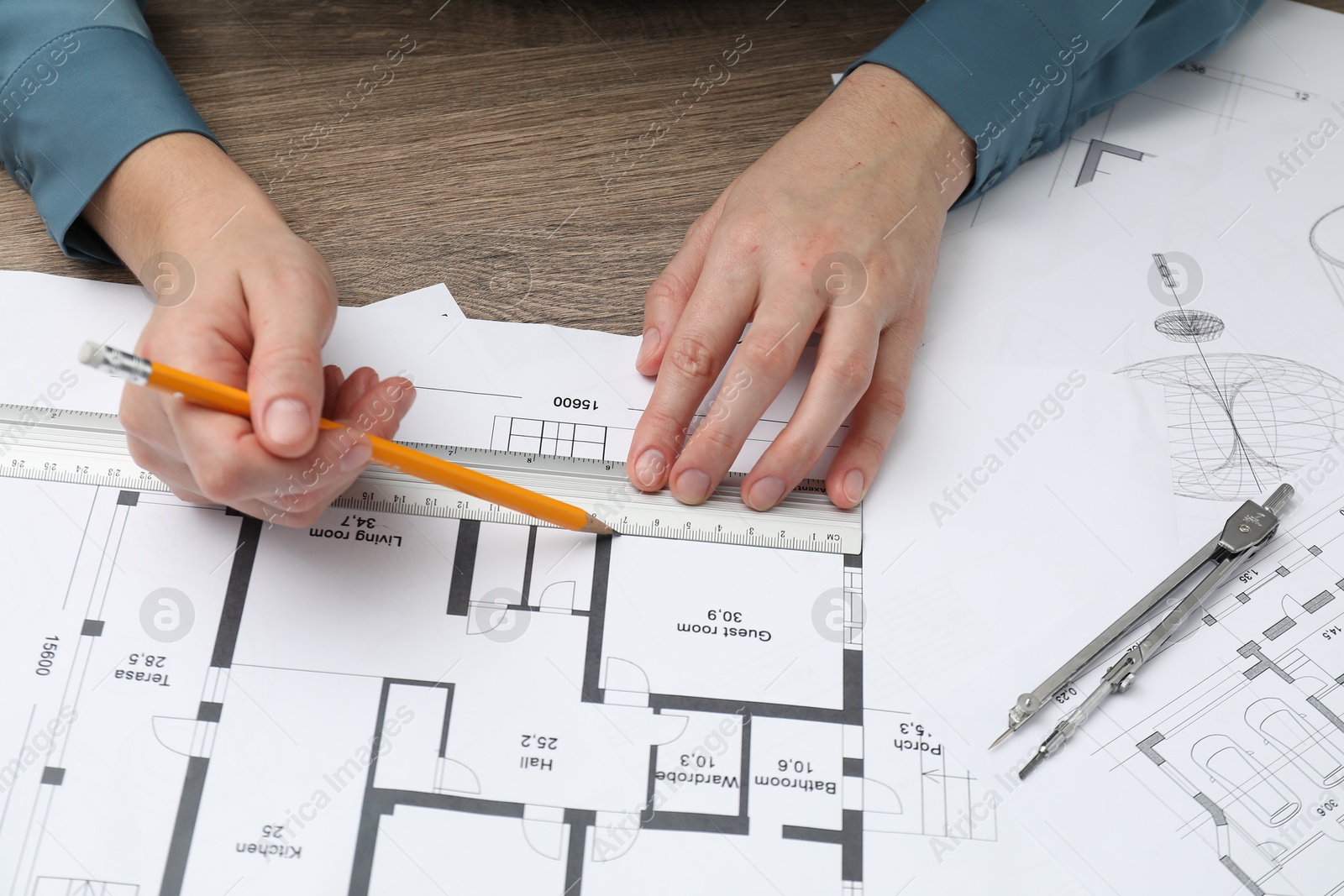 Photo of Architect working with project, closeup. Different technical drawings on wooden table