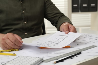 Photo of Architect working with project, closeup. Different technical drawings on white table