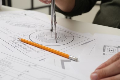 Engineer working with project, closeup. Different technical drawings on white table