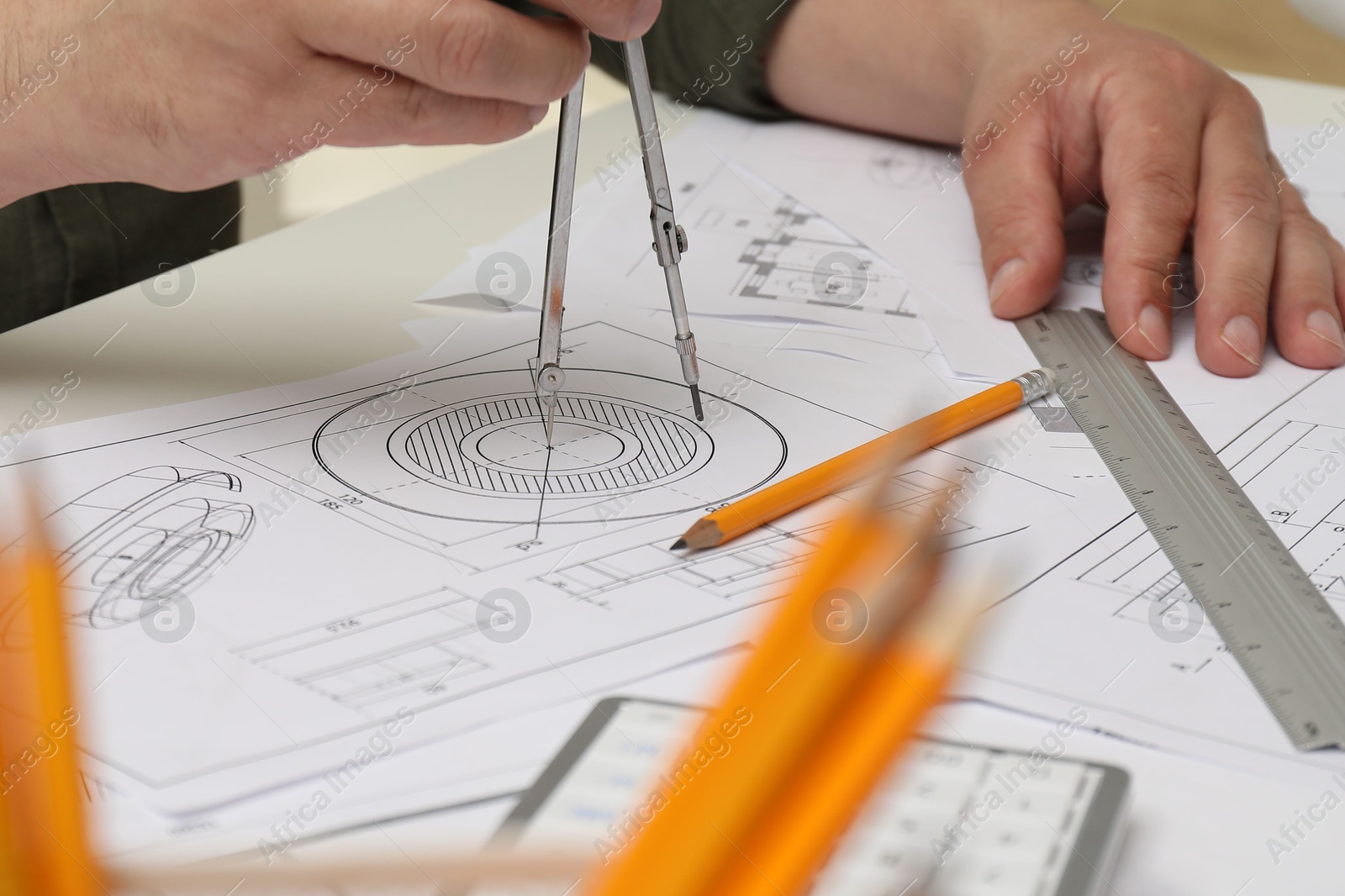 Photo of Engineer working with project, closeup. Different technical drawings on table