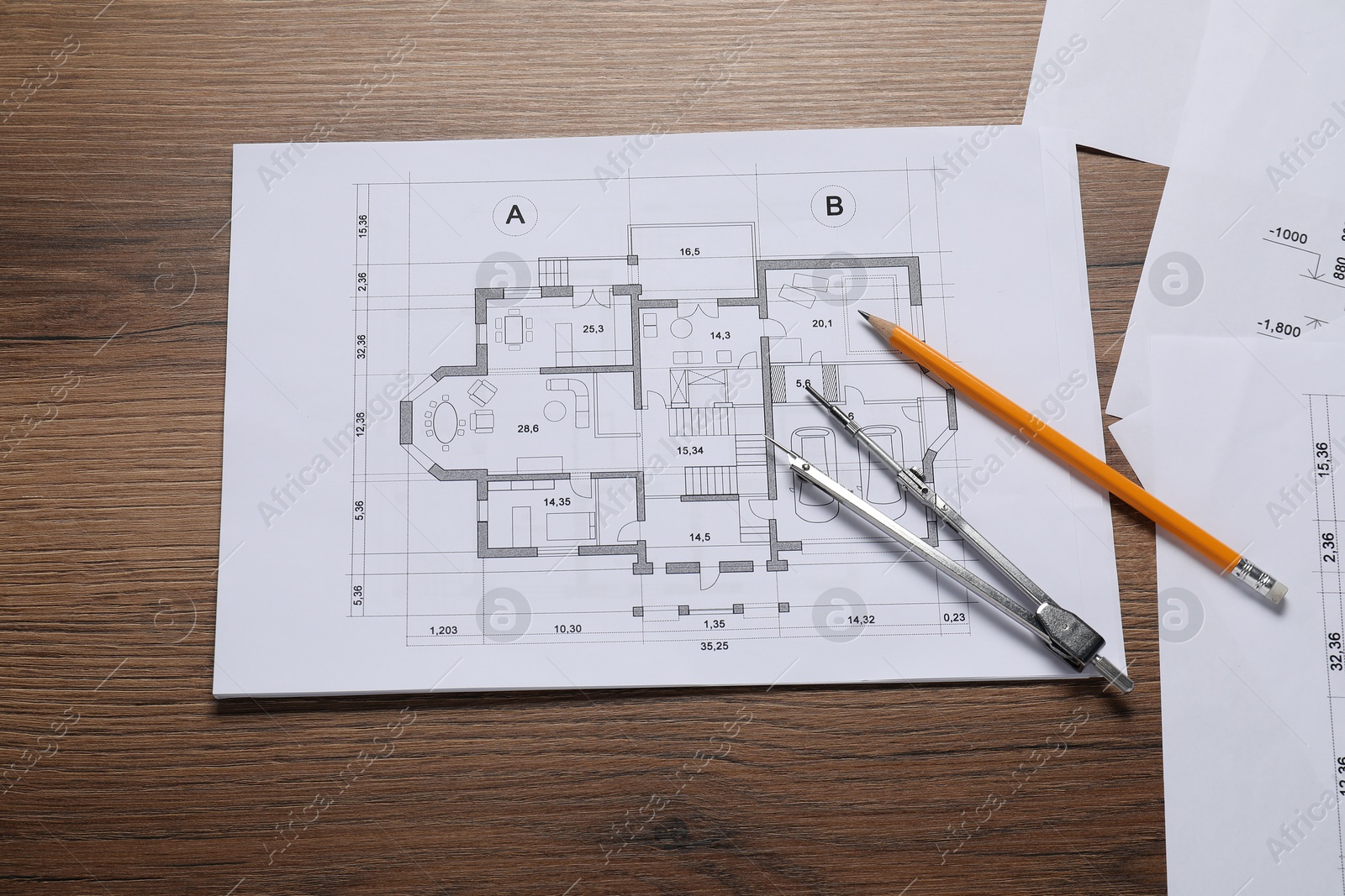 Photo of Different architectural drawings, pencil and divider on wooden table, flat lay