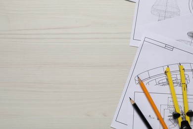 Different engineering drawings, pencils and divider on wooden table, flat lay. Space for text