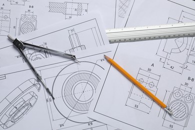 Different engineering drawings, pencil, ruler and divider on table, flat lay