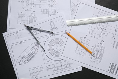 Different engineering drawings, pencil, ruler and divider on grey table, flat lay