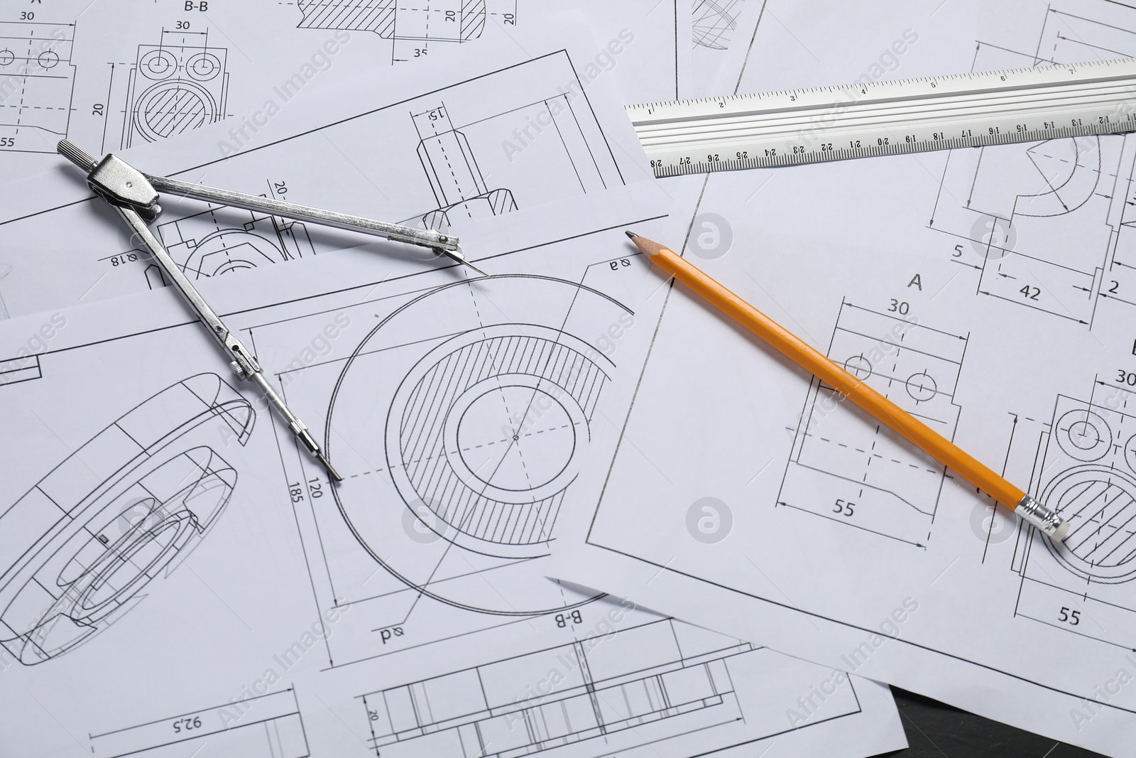 Photo of Different engineering drawings, pencil, ruler and divider on grey table, flat lay