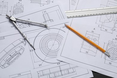 Different engineering drawings, pencil, ruler and divider on grey table, flat lay