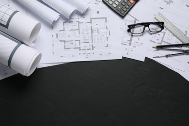 Photo of Different architectural drawings, ruler, divider and glasses on grey textured table, flat lay. Space for text