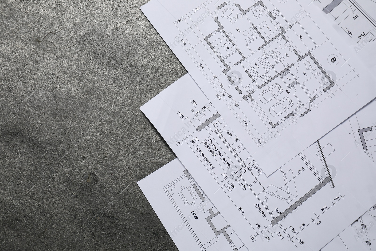 Photo of Different architectural drawings on grey textured table, flat lay. Space for text