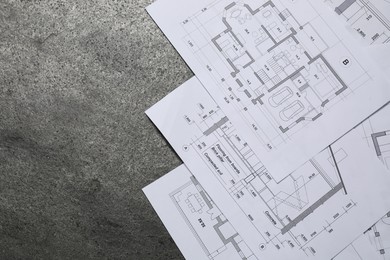 Different architectural drawings on grey textured table, flat lay. Space for text