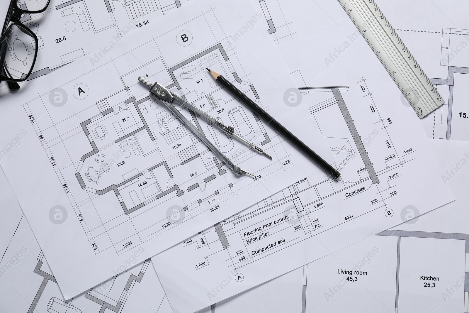 Photo of Different architectural drawings, ruler, divider, pencil and glasses on table, flat lay