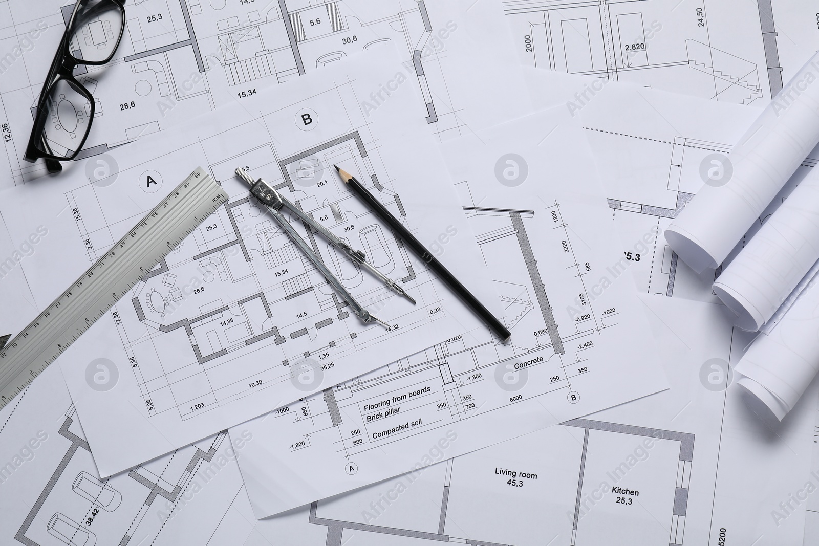 Photo of Different architectural drawings, ruler, divider, pencil and glasses on table, flat lay