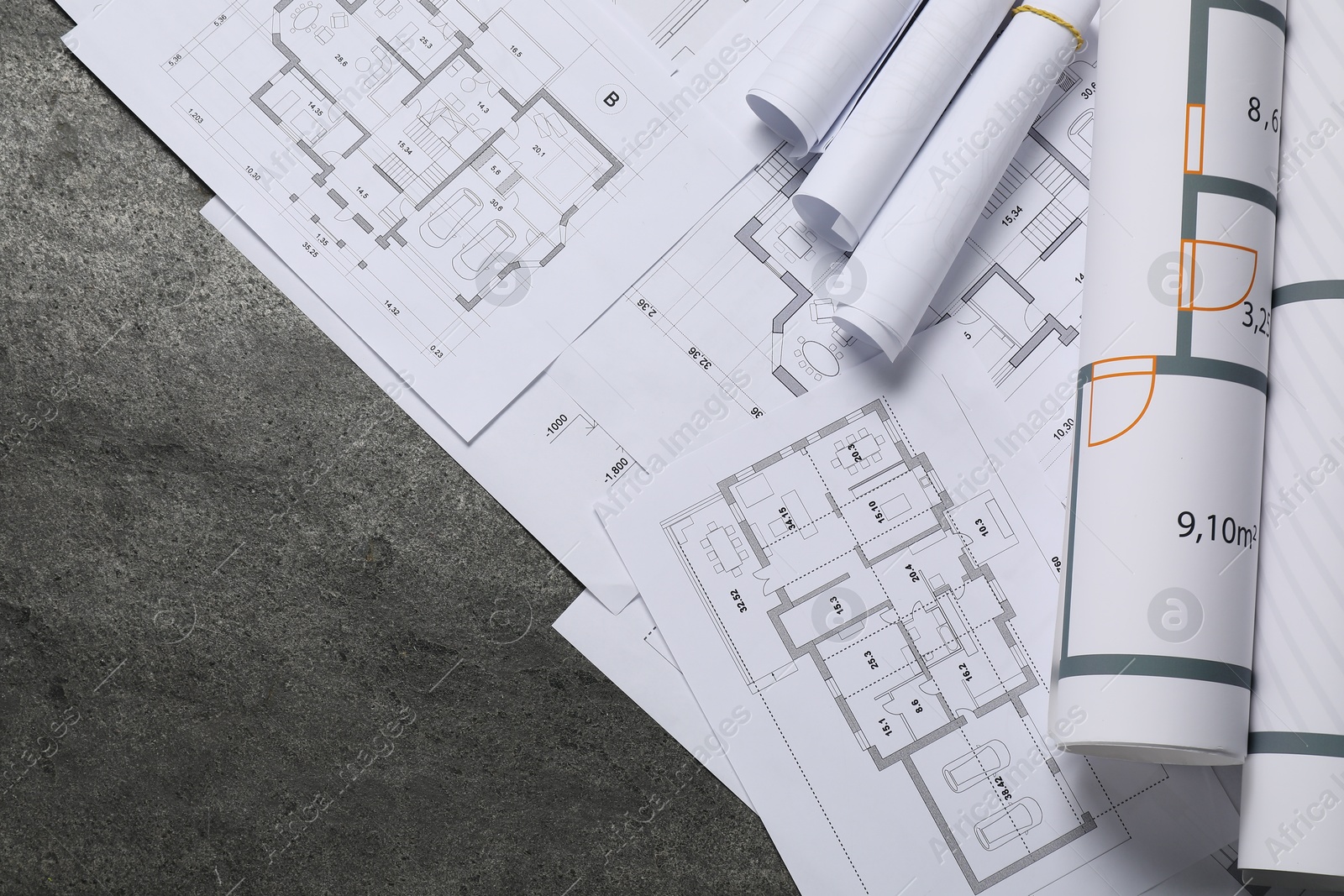 Photo of Different architectural drawings on grey textured table, flat lay. Space for text