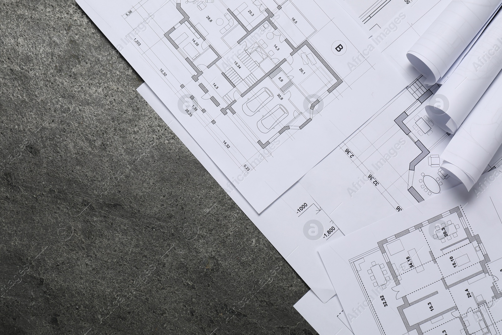 Photo of Different architectural drawings on grey textured table, flat lay. Space for text