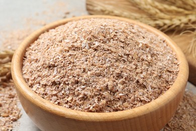 Photo of Wheat bran in bowl on table, closeup