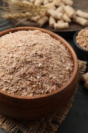 Wheat bran in bowl on black table