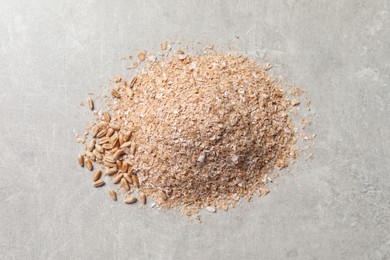 Pile of wheat bran on grey table, top view