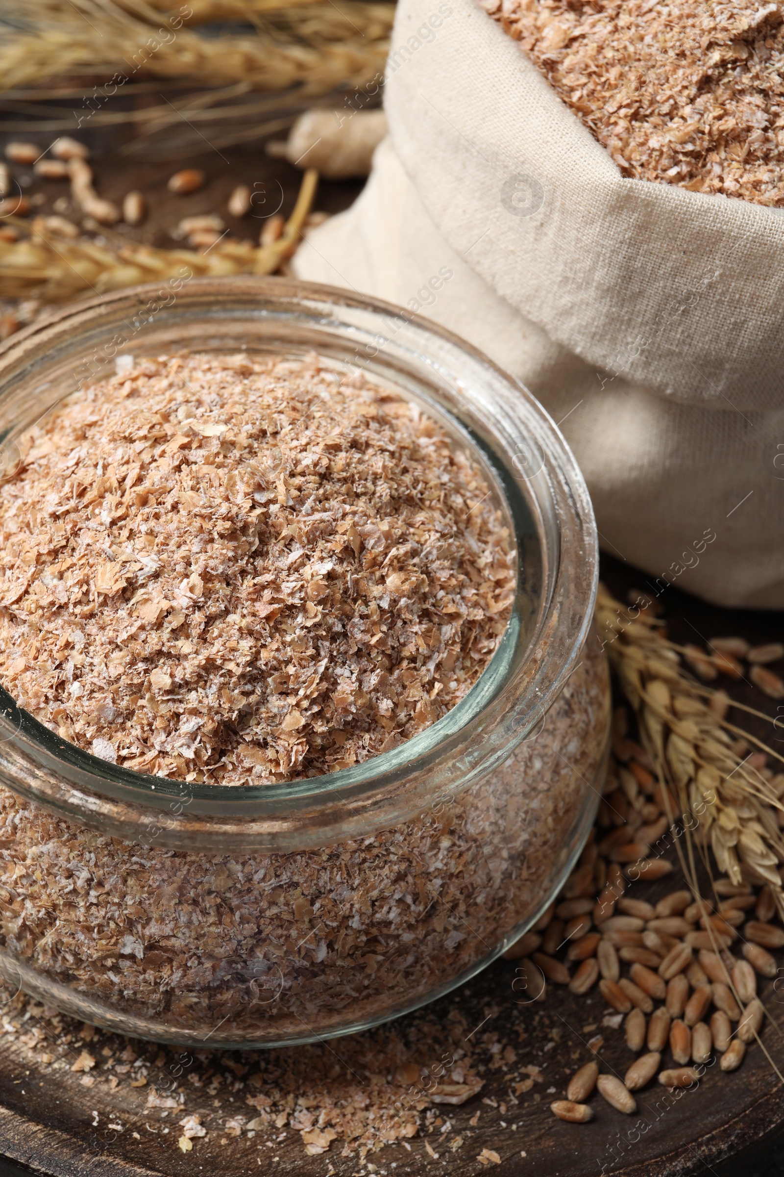 Photo of Jar of wheat bran on wooden tray