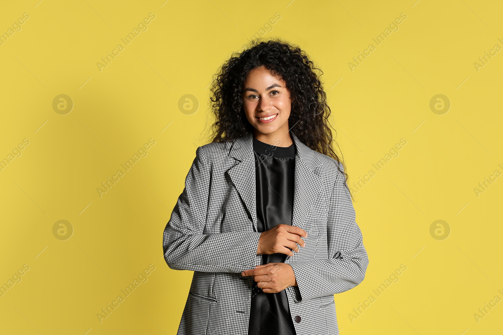 Photo of Beautiful woman in stylish jacket on yellow background