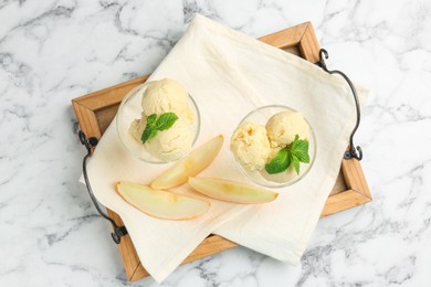 Photo of Scoops of melon sorbet with mint in glass dessert bowls and fresh fruit on white marble table, top view