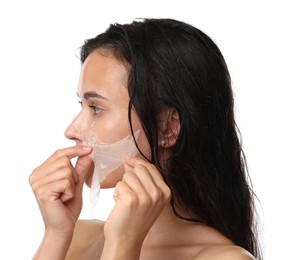 Beautiful woman peeling off face mask on white background