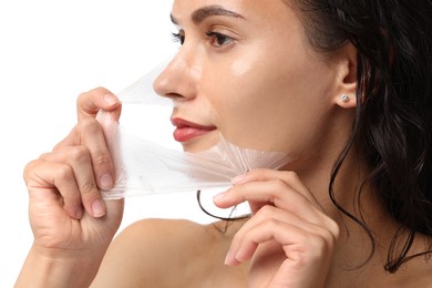 Beautiful woman peeling off face mask on white background, closeup