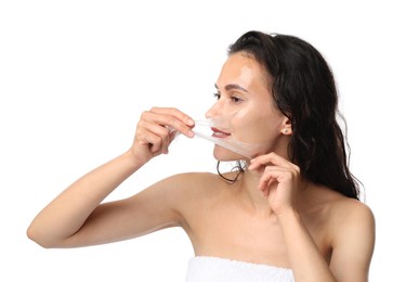 Photo of Beautiful woman peeling off face mask on white background