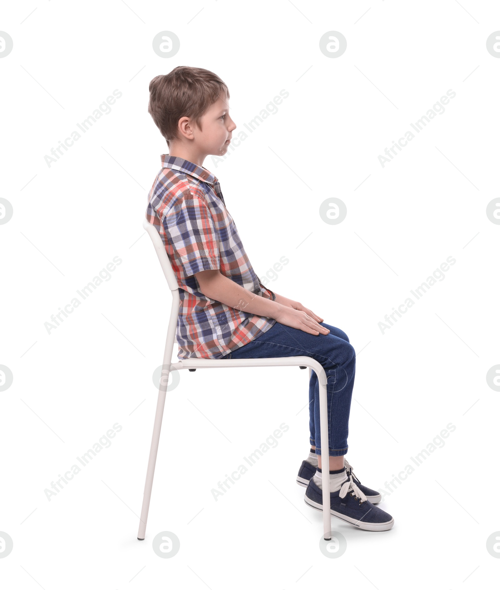 Photo of Boy with correct posture sitting on chair against white background