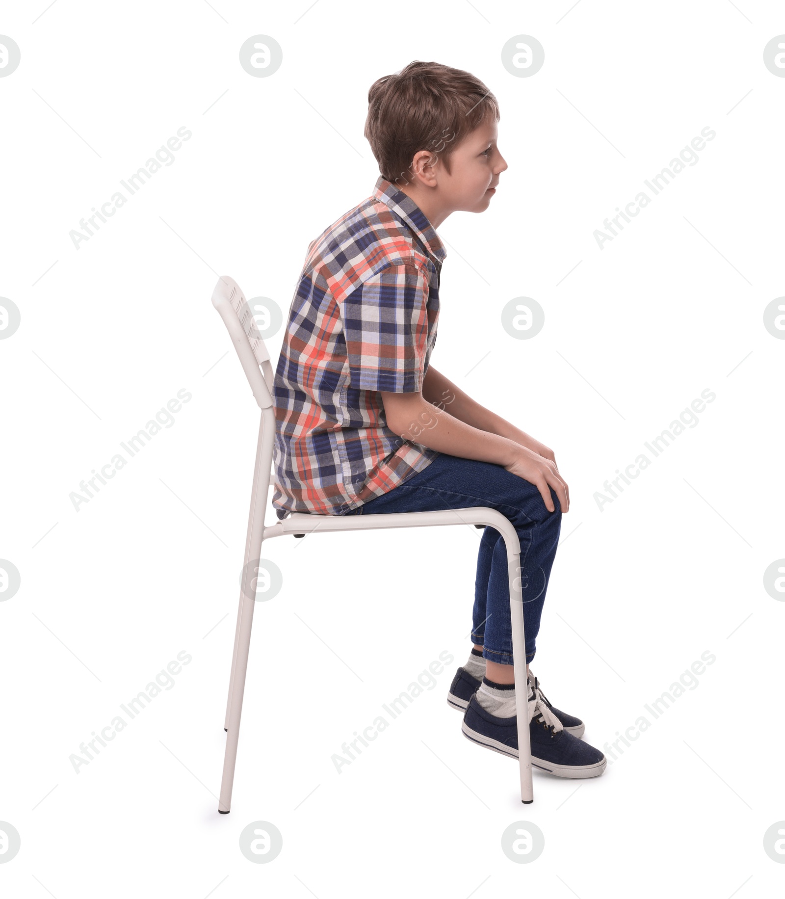 Photo of Boy with incorrect posture sitting on chair against white background