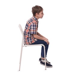 Boy with incorrect posture sitting on chair against white background