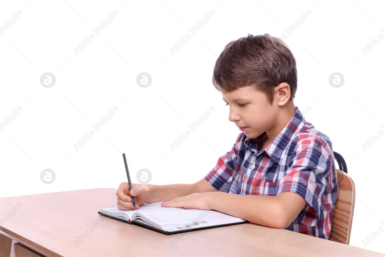 Photo of Boy with correct posture and notebook at wooden desk on white background